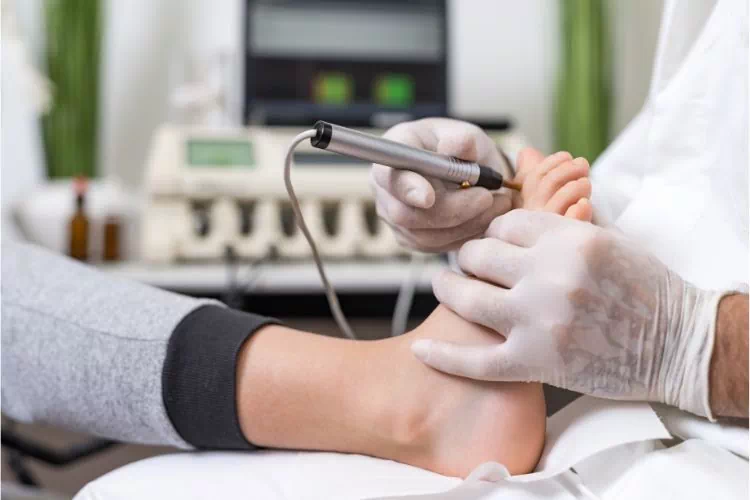 Thérapeute de la biorésonance effectuant un traitement sur les pieds d'un patient