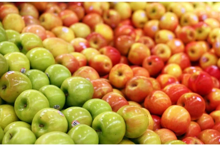 Des centaines de pommes de différentes couleurs et variétés sur une étale.