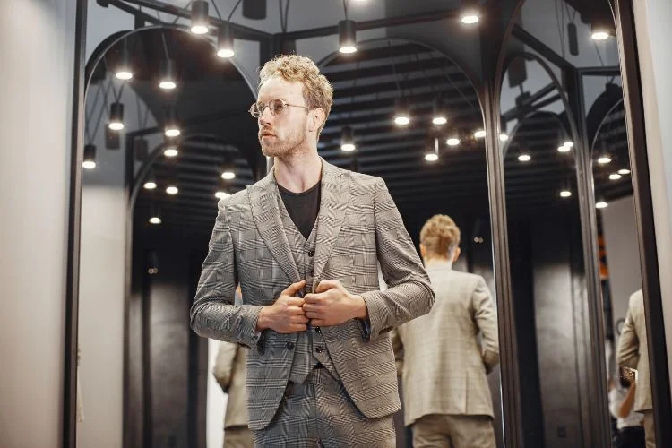 Un homme caucasien dans un costume et un gilet de costume strié.