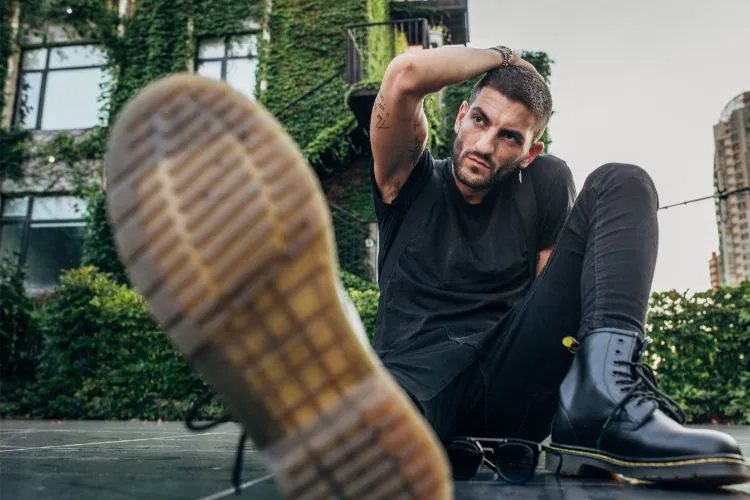 Un homme habillé entièrement en noir avec des bottes