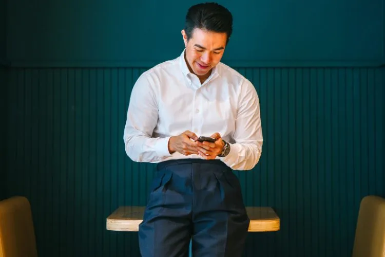 Un homme habillé avec une chemise blanche et un pantalon noir simple