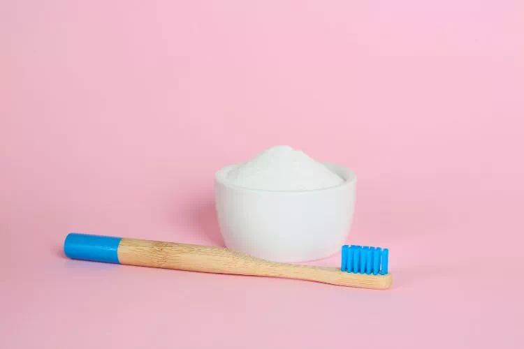 Brosse à côté d'un pot de bicarbonate de soude