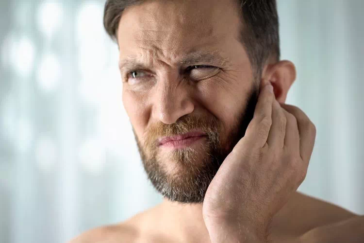 Homme qui se gratte les oreilles