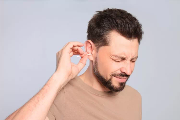 Homme qui se gratte les oreilles